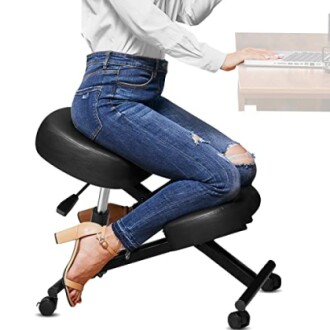Person sitting on ergonomic kneeling chair at desk