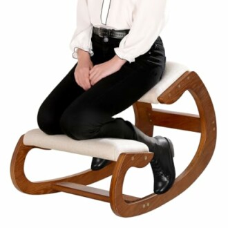 Person sitting on an ergonomic kneeling chair with wooden frame.