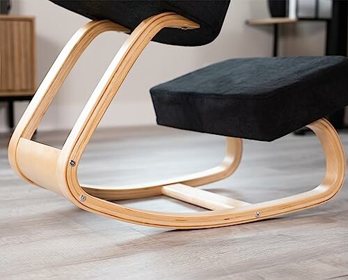Modern kneeling chair with wooden frame on a wooden floor