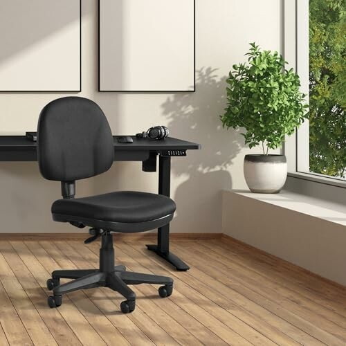 Office chair and desk next to a window with a potted plant.